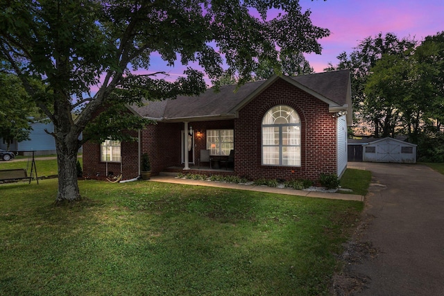 343 Belinda Pkwy, Mount Juliet, TN 37122 - view of front of house featuring a porch, driveway, a front yard, brick siding, and an outbuilding