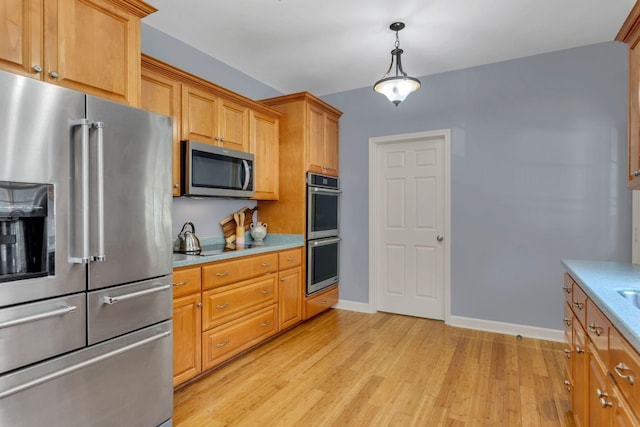 343 Belinda Pkwy, Mount Juliet, TN 37122 - kitchen with stainless steel appliances, light wood-style floors, light countertops, decorative light fixtures, and brown cabinets