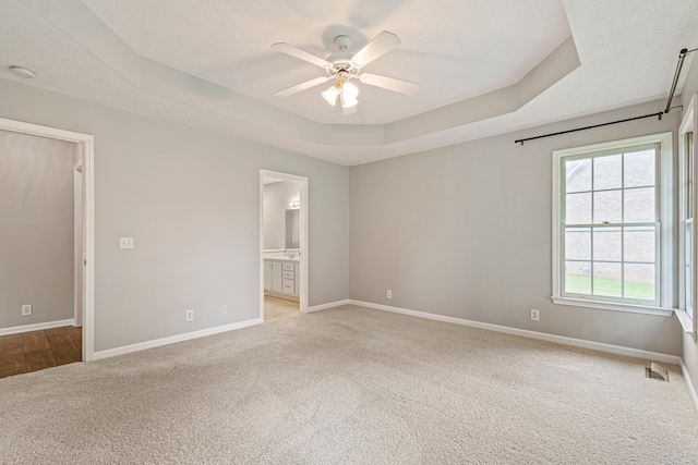 2415 Franklin Ln, Murfreesboro, TN 37130 - unfurnished bedroom featuring a tray ceiling, carpet, ensuite bathroom, a textured ceiling, and ceiling fan