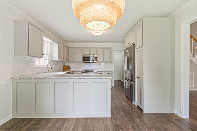 2415 Franklin Ln, Murfreesboro, TN 37130 - kitchen with stainless steel appliances, a peninsula, tasteful backsplash, a chandelier, and dark wood finished floors