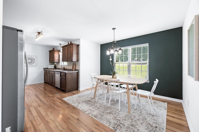 7566 S Swift Rd, Goodlettsville, TN 37072 - dining area featuring light wood-type flooring, a chandelier, and a barn door