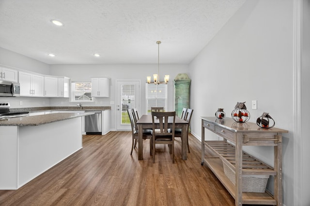 77 Frost St, Decherd, TN 37324 - kitchen featuring stainless steel appliances, wood finished floors, white cabinets, dark stone countertops, and a chandelier