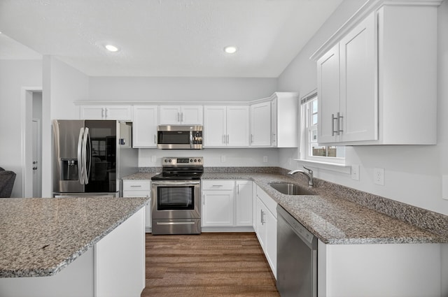 77 Frost St, Decherd, TN 37324 - kitchen with stainless steel appliances, white cabinetry, dark wood-type flooring, light stone countertops, and recessed lighting