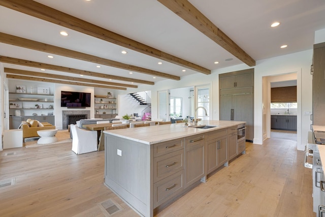 7555 Whiskey Rd, College Grove, TN 37046 - kitchen with gray cabinets, open floor plan, a center island with sink, a fireplace, and recessed lighting