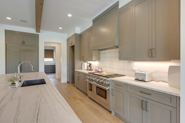 7555 Whiskey Rd, College Grove, TN 37046 - kitchen featuring premium appliances, custom range hood, light wood-style flooring, light stone countertops, and beam ceiling