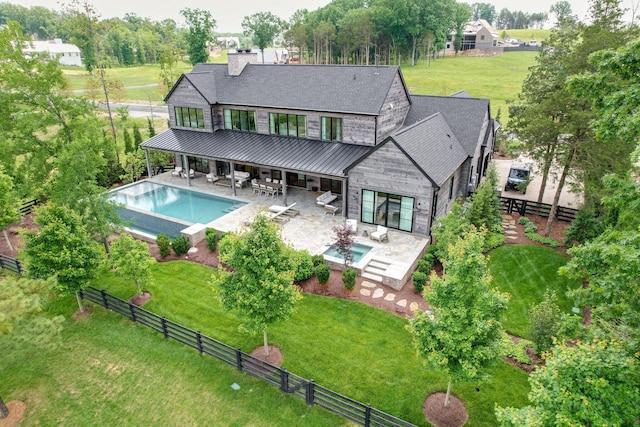 7555 Whiskey Rd, College Grove, TN 37046 - back of house featuring a standing seam roof, a fenced backyard, a patio area, a metal roof, and stone siding