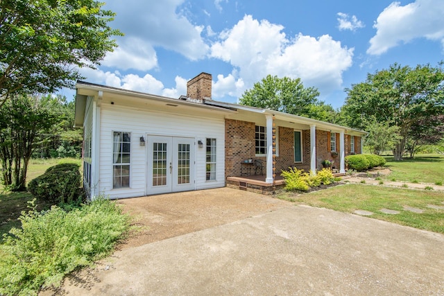 996 Matrose Carrolls Rd, Michie, TN 38357 - back of property featuring a chimney, french doors, brick siding, covered porch, and a lawn