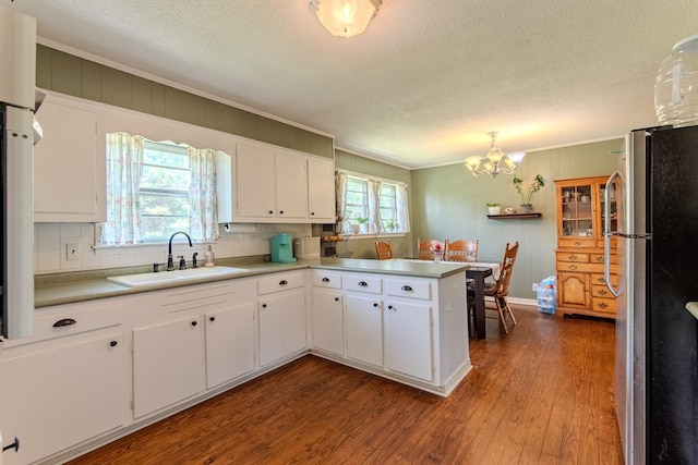 996 Matrose Carrolls Rd, Michie, TN 38357 - kitchen with freestanding refrigerator, crown molding, wood finished floors, a chandelier, and white cabinetry