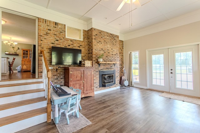 996 Matrose Carrolls Rd, Michie, TN 38357 - unfurnished living room featuring wood finished floors, a brick fireplace, ceiling fan, stairs, and brick wall