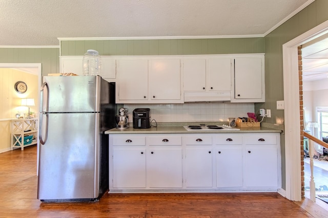 996 Matrose Carrolls Rd, Michie, TN 38357 - kitchen with freestanding refrigerator, ornamental molding, wood finished floors, decorative backsplash, and white cabinets