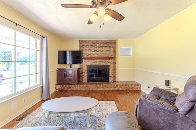996 Matrose Carrolls Rd, Michie, TN 38357 - living room with wood finished floors, healthy amount of natural light, a textured ceiling, a brick fireplace, and ornamental molding