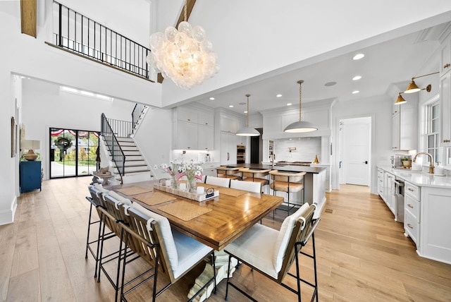8869 Edgecomb Dr, College Grove, TN 37046 - dining space with stairs, light wood-style floors, a high ceiling, recessed lighting, and a chandelier