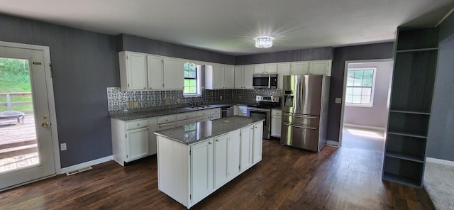 2877 Bryant Rd, Culleoka, TN 38451 - kitchen with appliances with stainless steel finishes, white cabinets, tasteful backsplash, dark wood-type flooring, and a kitchen island