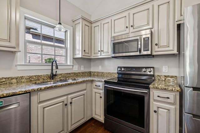 1037 Irish Way, Spring Hill, TN 37174 - kitchen with stainless steel appliances, cream cabinetry, dark wood-style floors, light stone counters, and vaulted ceiling