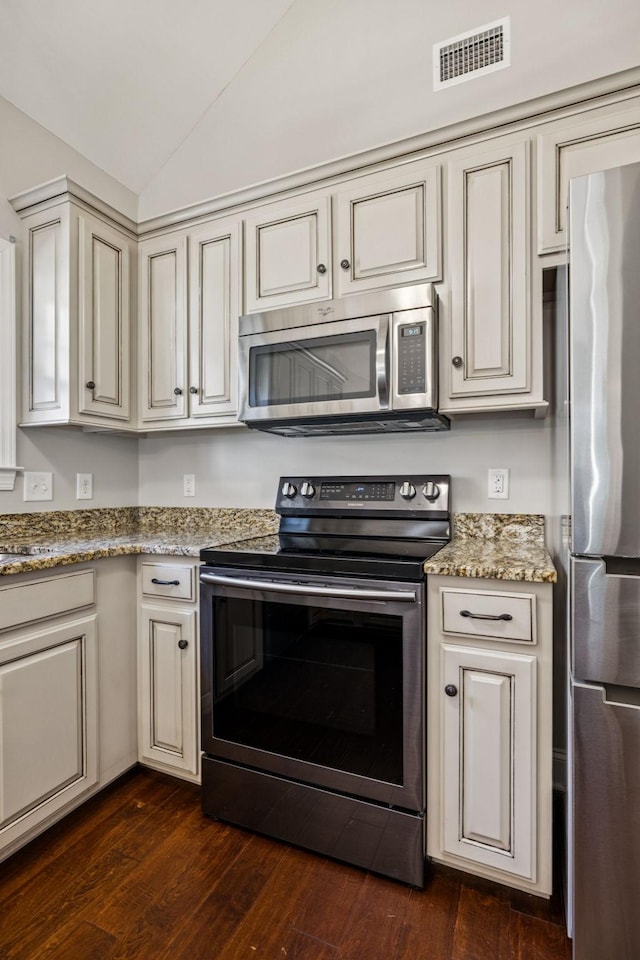 1037 Irish Way, Spring Hill, TN 37174 - kitchen with stainless steel appliances, cream cabinets, dark wood-type flooring, vaulted ceiling, and light stone counters