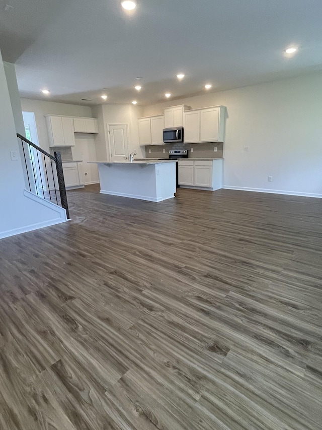 462 Jet Stream Dr, La Vergne, TN 37086 - kitchen with stainless steel microwave, open floor plan, white cabinetry, dark wood-style floors, and recessed lighting
