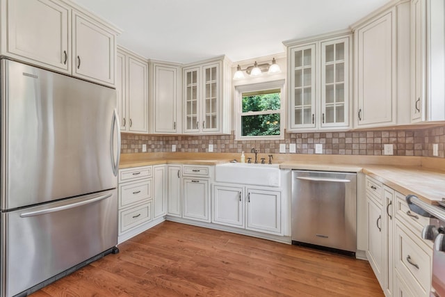 3035 Culleoka Hwy, Culleoka, TN 38451 - kitchen featuring appliances with stainless steel finishes, light countertops, backsplash, and light wood-style flooring