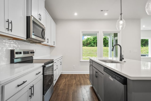 1922 Hildebrand Ln, Columbia, TN 38401 - kitchen featuring appliances with stainless steel finishes, light countertops, dark wood-style flooring, an island with sink, and pendant lighting