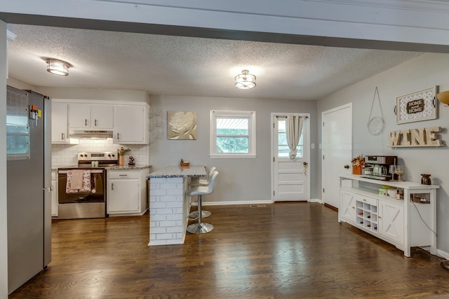 528 Maple St, Pulaski, TN 38478 - kitchen with electric range, white cabinets, under cabinet range hood, decorative backsplash, and dark wood-style floors