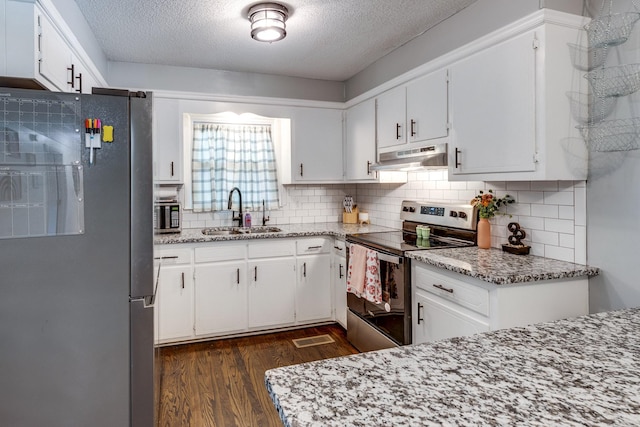 528 Maple St, Pulaski, TN 38478 - kitchen featuring appliances with stainless steel finishes, under cabinet range hood, a textured ceiling, dark wood-style flooring, and backsplash