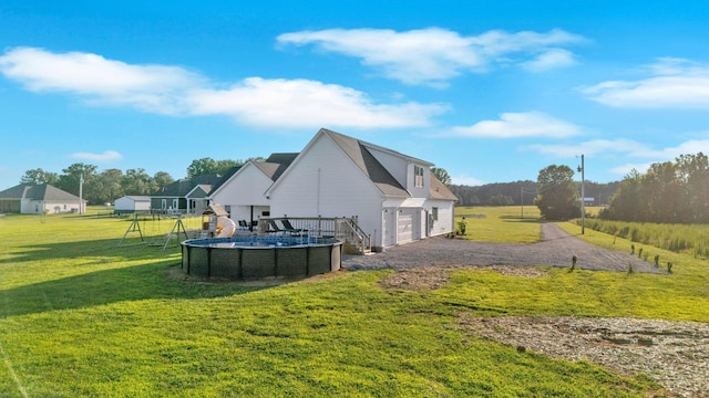426 Maple Bend Rd, Winchester, TN 37398 - rear view of property with an attached garage, an outdoor pool, driveway, and a lawn