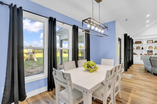 426 Maple Bend Rd, Winchester, TN 37398 - dining room featuring light wood-type flooring, healthy amount of natural light, lofted ceiling, built in shelves, and a chandelier