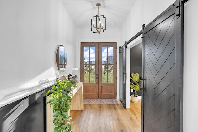 426 Maple Bend Rd, Winchester, TN 37398 - entrance foyer featuring a barn door, light wood-style flooring, and a chandelier