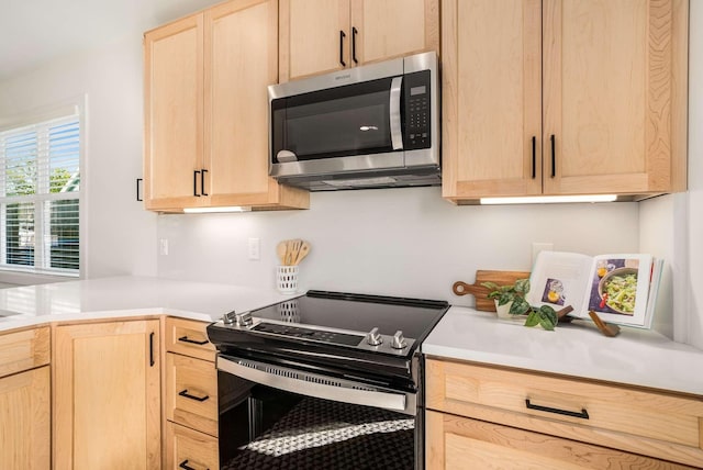 1823 River Dr, Nashville, TN 37218 - kitchen featuring stainless steel microwave, electric stove, light brown cabinets, and light countertops