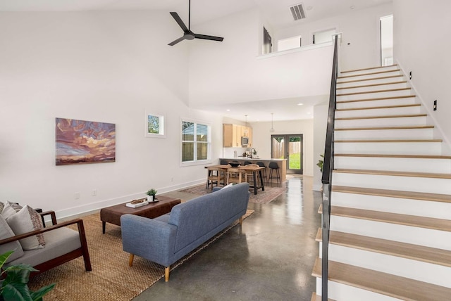 1823 River Dr, Nashville, TN 37218 - living area featuring a ceiling fan, stairs, a high ceiling, and concrete flooring