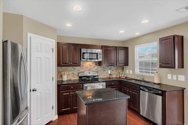 2008 Kingston Pl, Spring Hill, TN 37174 - kitchen featuring appliances with stainless steel finishes, a kitchen island, dark wood-style flooring, decorative backsplash, and dark brown cabinetry
