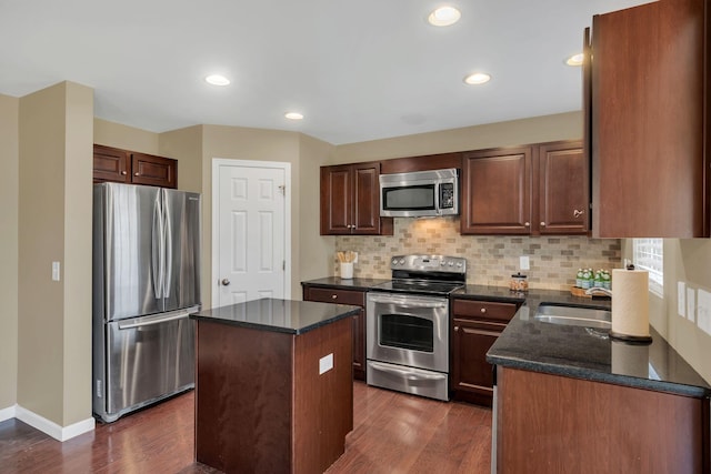 2008 Kingston Pl, Spring Hill, TN 37174 - kitchen with appliances with stainless steel finishes, backsplash, dark wood-type flooring, a center island, and recessed lighting