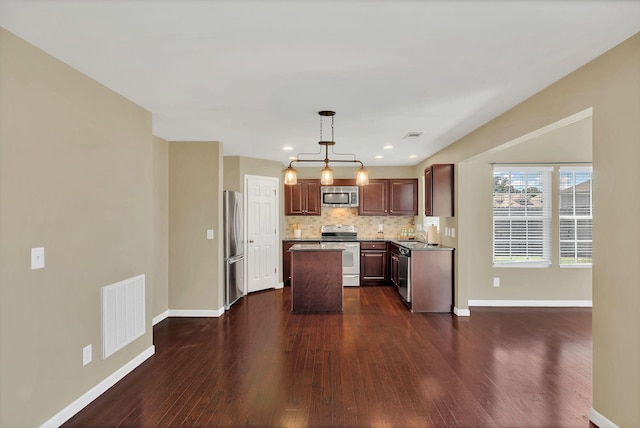 2008 Kingston Pl, Spring Hill, TN 37174 - kitchen with appliances with stainless steel finishes, dark wood-style floors, a center island, decorative backsplash, and a chandelier