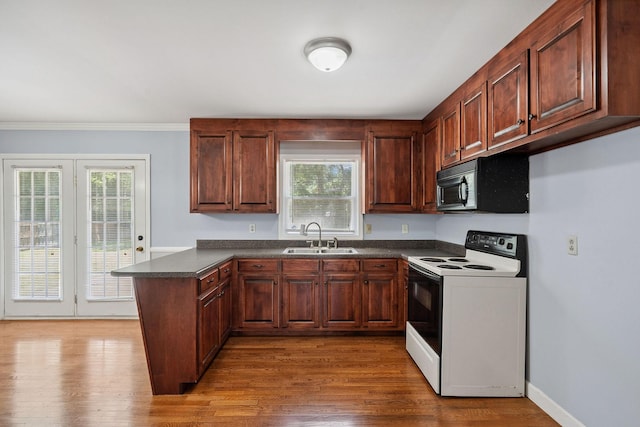 2311 Mayfair Ave, Murfreesboro, TN 37130 - kitchen featuring electric range, black microwave, dark countertops, a peninsula, and wood finished floors