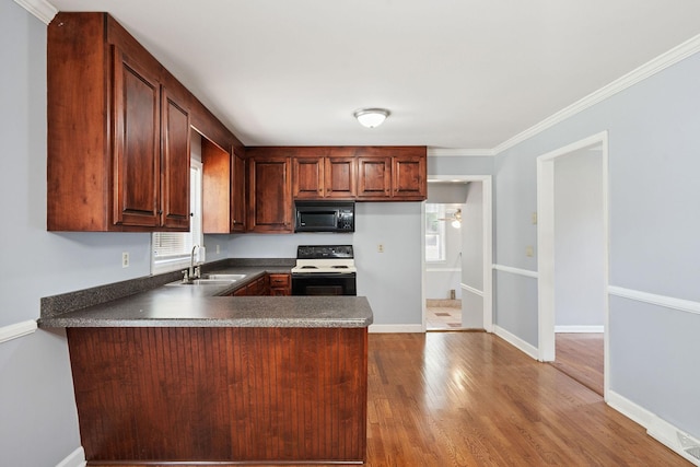 2311 Mayfair Ave, Murfreesboro, TN 37130 - kitchen with black appliances, dark countertops, a peninsula, wood finished floors, and ornamental molding
