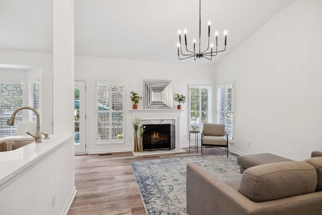 201 Hideaway Trl, Franklin, TN 37069 - living room with plenty of natural light, light wood-style flooring, a chandelier, a high end fireplace, and high vaulted ceiling