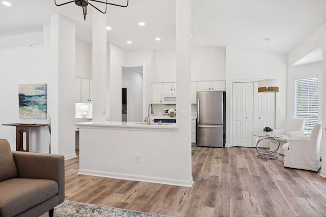 201 Hideaway Trl, Franklin, TN 37069 - kitchen featuring freestanding refrigerator, open floor plan, white microwave, white cabinetry, and light wood finished floors