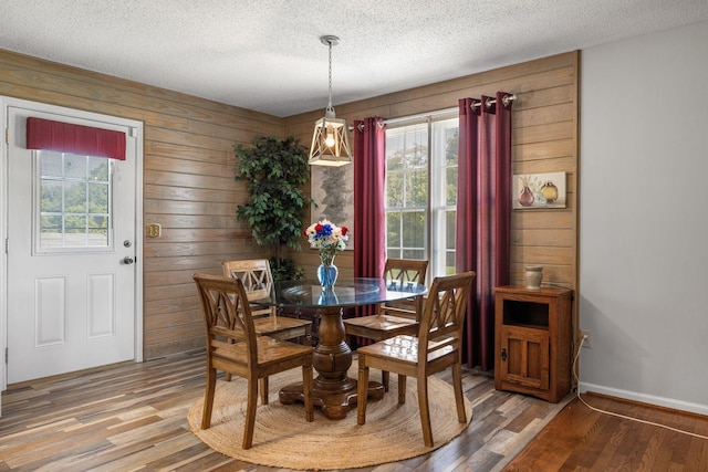 4628 Dugger Rd, Culleoka, TN 38451 - dining space featuring a textured ceiling, light wood-style flooring, and wood walls