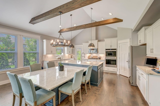 607 Beamon Dr, Franklin, TN 37064 - kitchen featuring stainless steel appliances, a large island with sink, beamed ceiling, white cabinets, and decorative backsplash