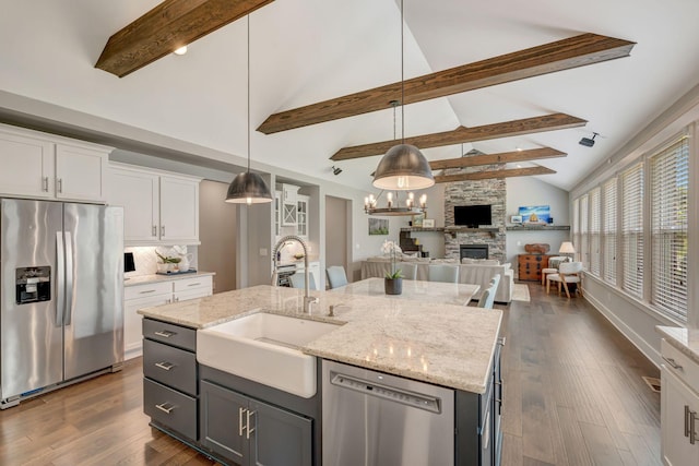 607 Beamon Dr, Franklin, TN 37064 - kitchen featuring stainless steel appliances, a stone fireplace, white cabinetry, open floor plan, and beam ceiling