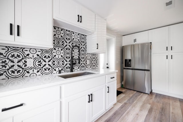 7365 Coldwater Rd, Fairview, TN 37062 - kitchen with stainless steel fridge with ice dispenser, light countertops, decorative backsplash, light wood finished floors, and white cabinets