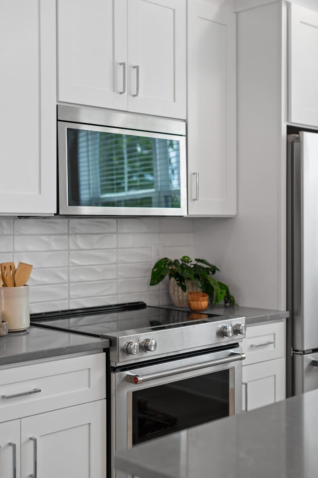 700 N Dupont Ave Unit 207, Madison, TN 37115 - kitchen featuring stainless steel appliances, backsplash, and white cabinetry