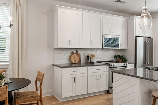 700 N Dupont Ave Unit 207, Madison, TN 37115 - kitchen with stainless steel appliances, dark countertops, light wood finished floors, and tasteful backsplash