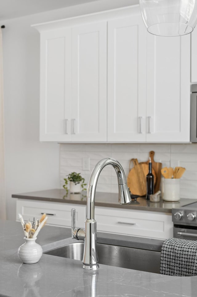 700 N Dupont Ave Unit 207, Madison, TN 37115 - kitchen view of decorative backsplash, white cabinets, and dark countertops