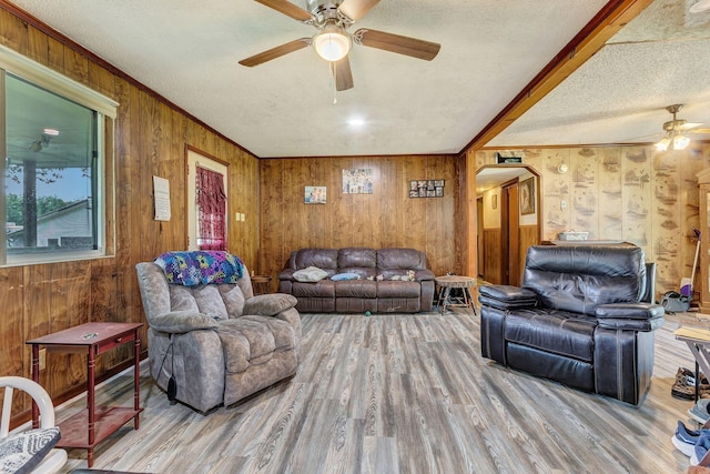111 School St, Cumberland Furnace, TN 37051 - living area featuring a ceiling fan, wood walls, a textured ceiling, wood finished floors, and arched walkways