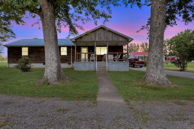 111 School St, Cumberland Furnace, TN 37051 - view of front facade with a porch, a lawn, and a metal roof