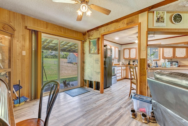 111 School St, Cumberland Furnace, TN 37051 - doorway to outside with a ceiling fan, wooden walls, light wood-style floors, a textured ceiling, and crown molding