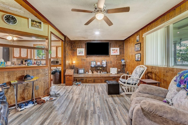 111 School St, Cumberland Furnace, TN 37051 - living area with ceiling fan, wood finished floors, a textured ceiling, ornamental molding, and wooden walls