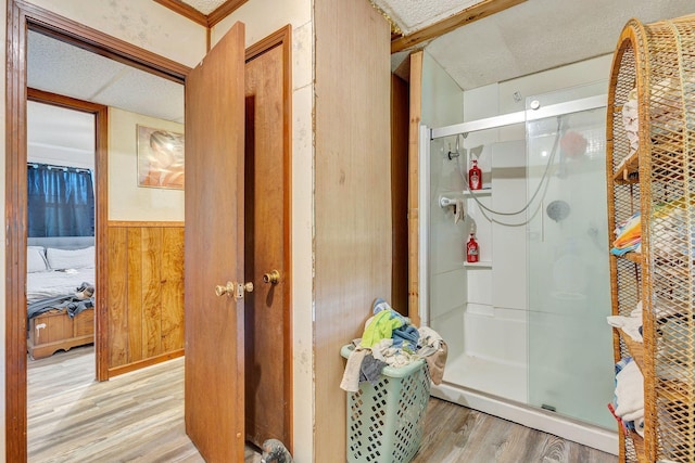 111 School St, Cumberland Furnace, TN 37051 - bathroom featuring wood finished floors, a shower stall, a textured ceiling, wood walls, and connected bathroom