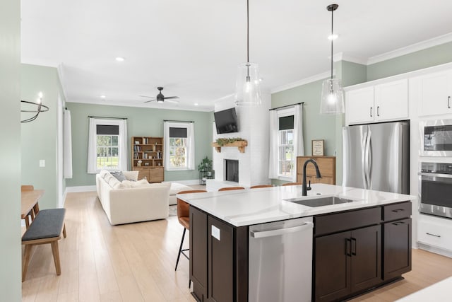 2618 Buckner Ln, Thompsons Station, TN 37179 - kitchen with stainless steel appliances, ornamental molding, ceiling fan, light countertops, and a kitchen island with sink