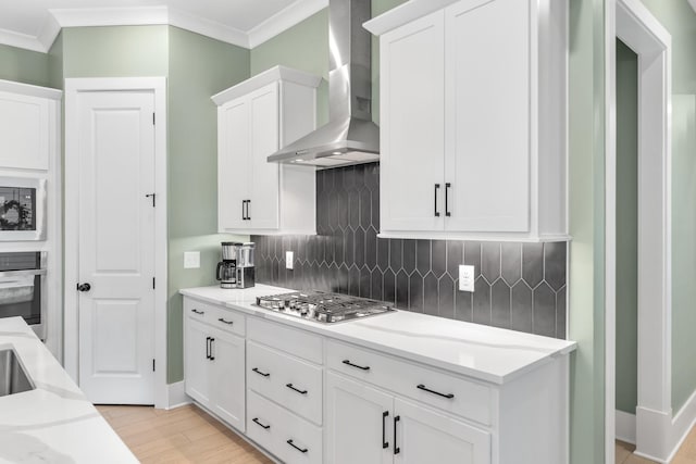 2618 Buckner Ln, Thompsons Station, TN 37179 - kitchen featuring wall chimney exhaust hood, appliances with stainless steel finishes, crown molding, backsplash, and light wood finished floors